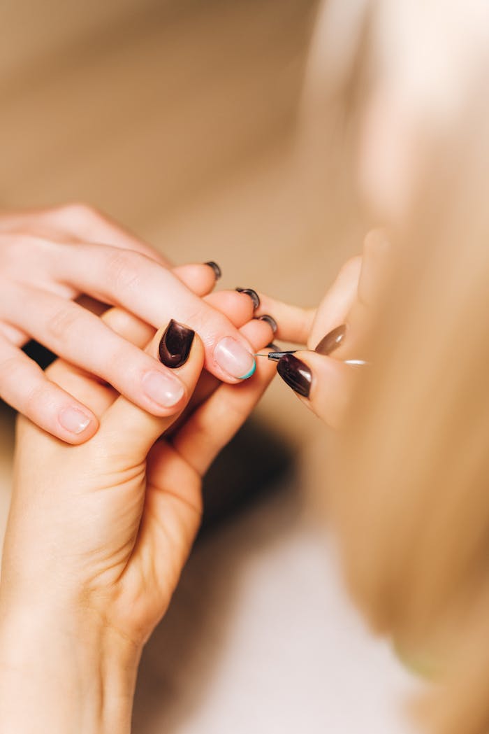 Detailed view of a professional manicurist working on a clients nails, showcasing nail care.